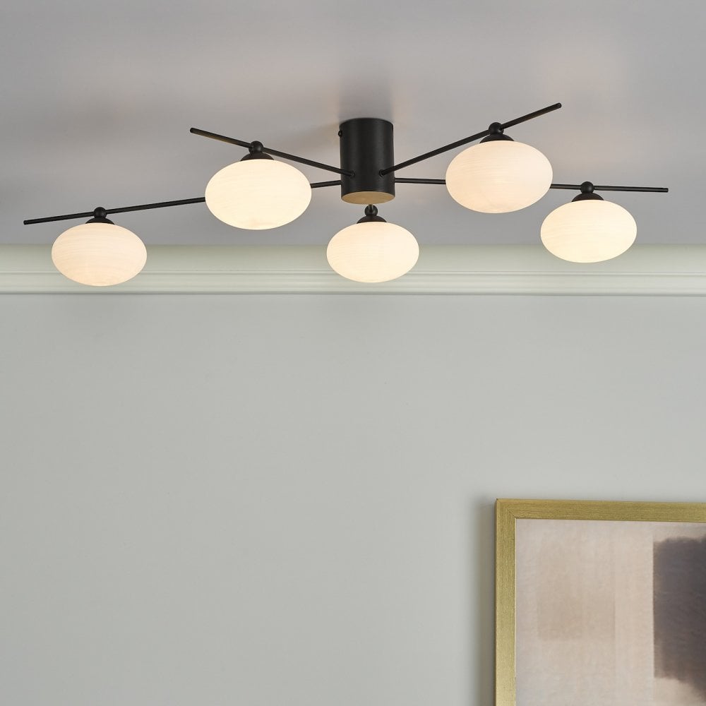 Black and white modern ceiling light with five orb-shaped diffusers installed.