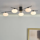 Black and white modern ceiling light with five orb-shaped diffusers installed.