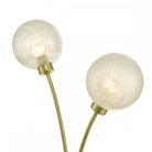 Close-up of the spherical, textured glass shades on a modern brass table lamp.
