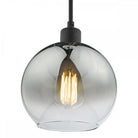Close-up of a smoked glass pendant light with a vintage-style filament bulb inside.