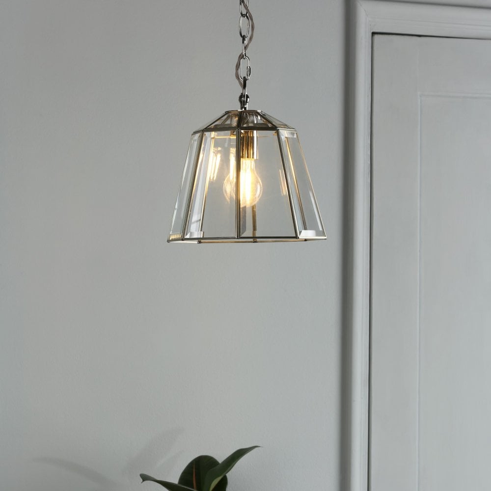 Polished nickel pendant light with clear glass shade in a modern hallway.