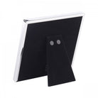Rear view of a white photo frame showing its black felt stand.