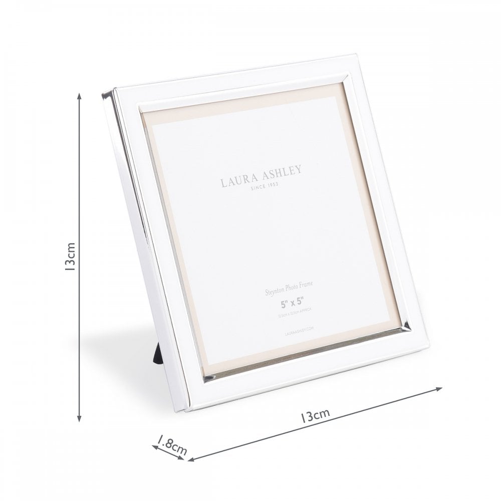 A white photo frame with dimensions 13cm x 13cm x 1.8cm, with a stand.