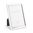 Single silver photo frame with a white mount, angled to show its design.