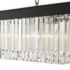 Close-up of the illuminated clear crystal rods and black frame of a rectangular chandelier.