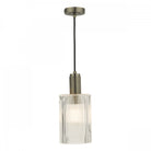 A single ribbed glass and antique brass pendant light on a white background, illuminated.