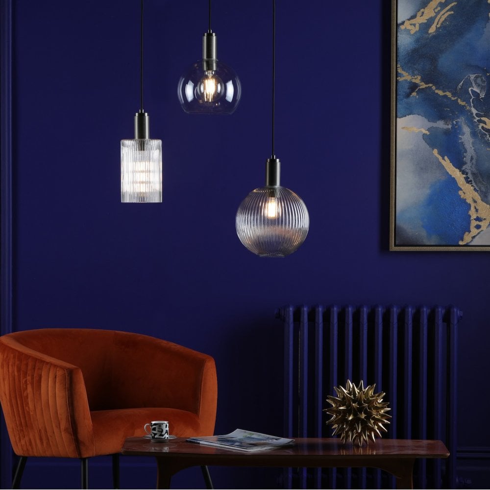Three pendant lights: ribbed glass, clear glass, and ribbed globe in a blue room.