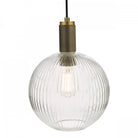 A clear, ribbed glass globe pendant light with a brass top and visible bulb.