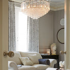 A luxurious living room featuring a grand crystal chandelier and elegant decor.
