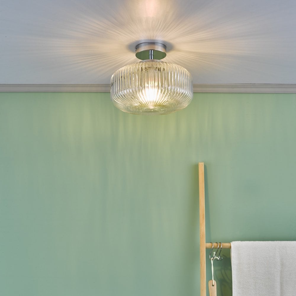 The ribbed glass flush ceiling light installed in a room with green walls.