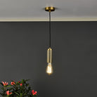 A brass pendant light with an exposed bulb hanging in a room with a dark grey wall.