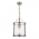 A vintage style pendant light with a clear glass shade and antique brass finish, isolated on white.