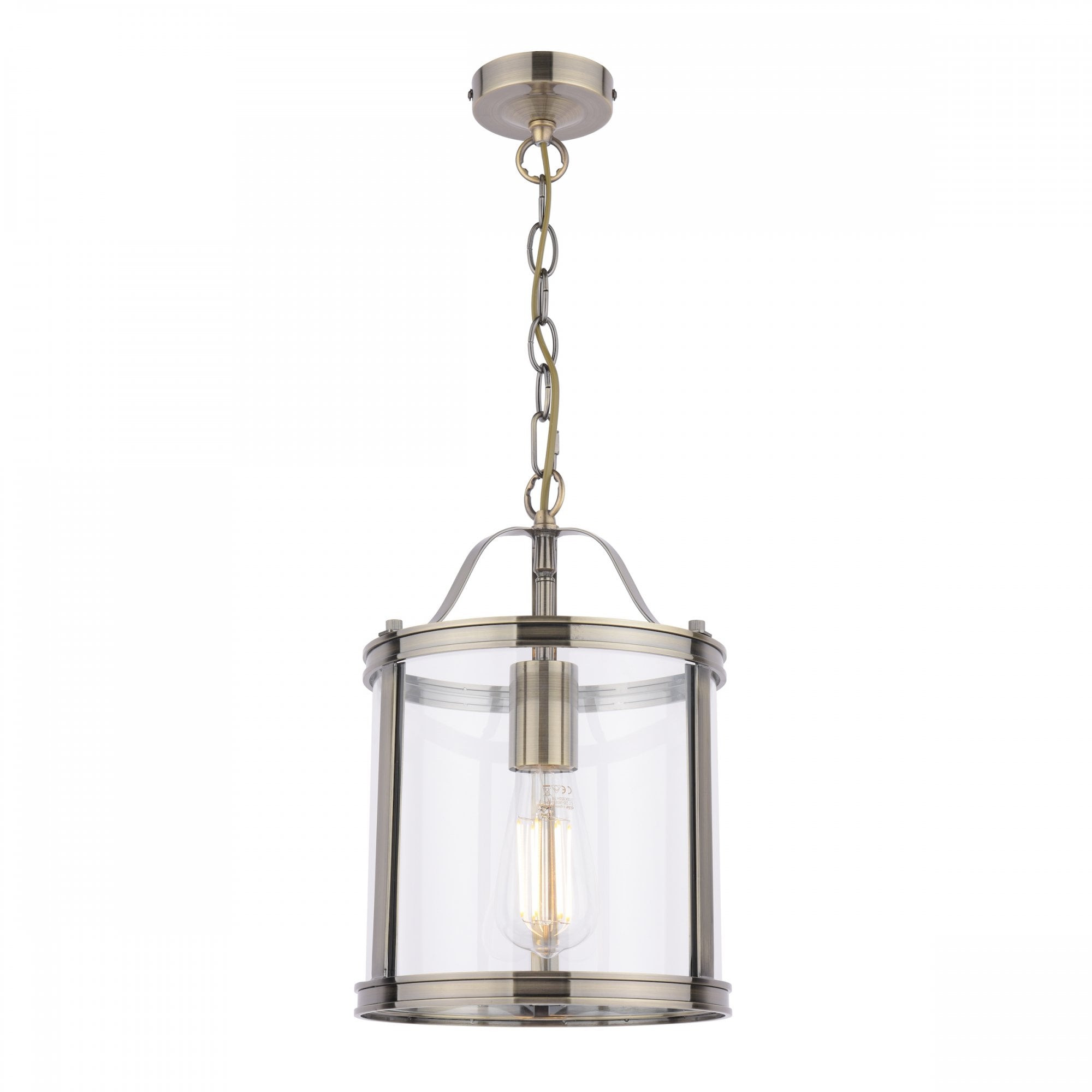 A vintage style pendant light with a clear glass shade and antique brass finish, isolated on white.