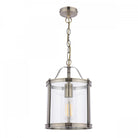 A vintage style pendant light with a clear glass shade and antique brass finish, isolated on white.