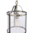Close-up of a vintage style pendant light with a clear glass shade and antique brass finish.