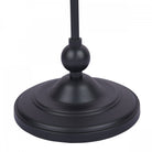 The round, dark-colored base of a classic floor lamp, showing its sturdy design.