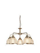A five-arm chandelier with antique brass finish and frosted glass shades.