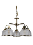 A five-arm antique brass chandelier with speckled clear glass shades.
