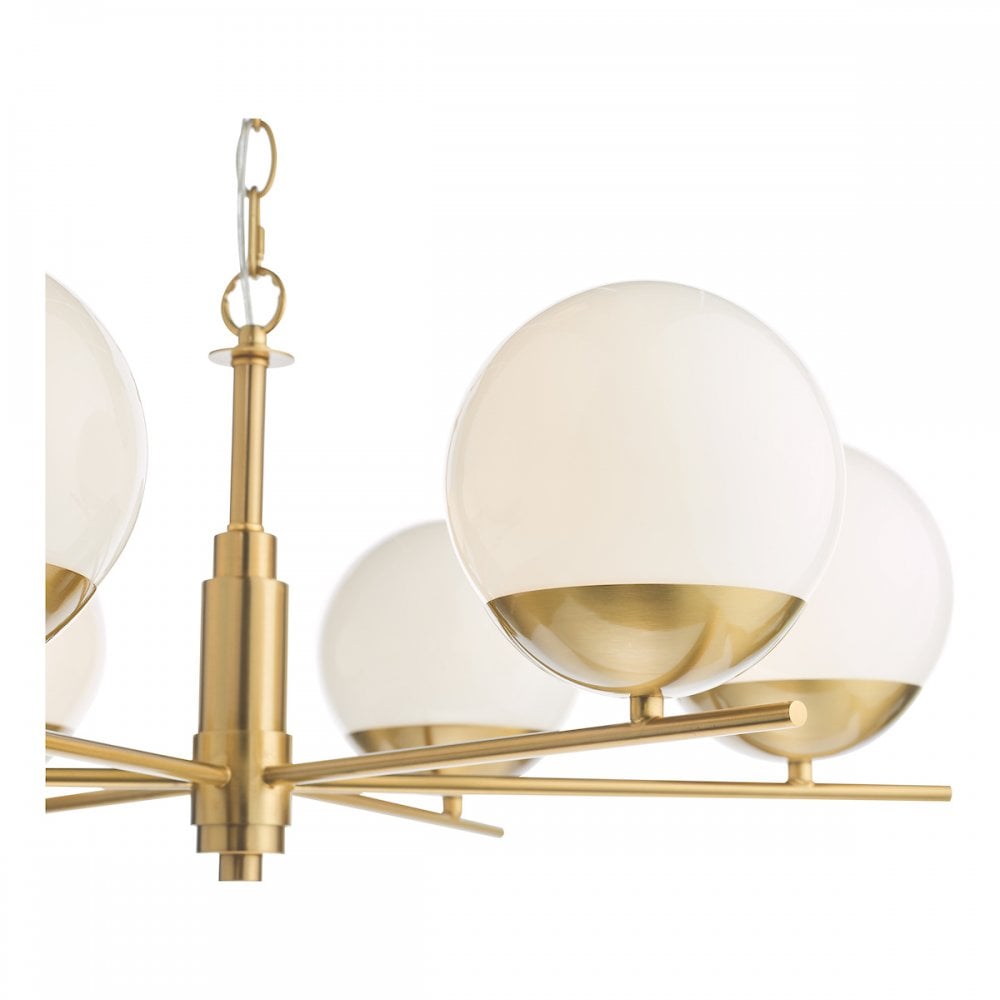 A close-up view of the modern brass chandelier, focusing on the white globe lights.
