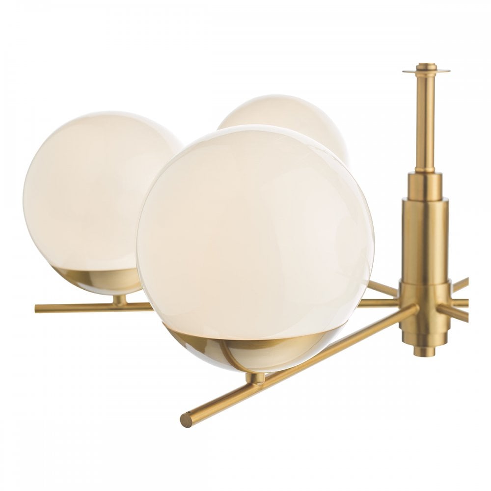 A detailed close-up of three white globe lights and the brass frame of the chandelier.