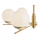 A detailed close-up of three white globe lights and the brass frame of the chandelier.