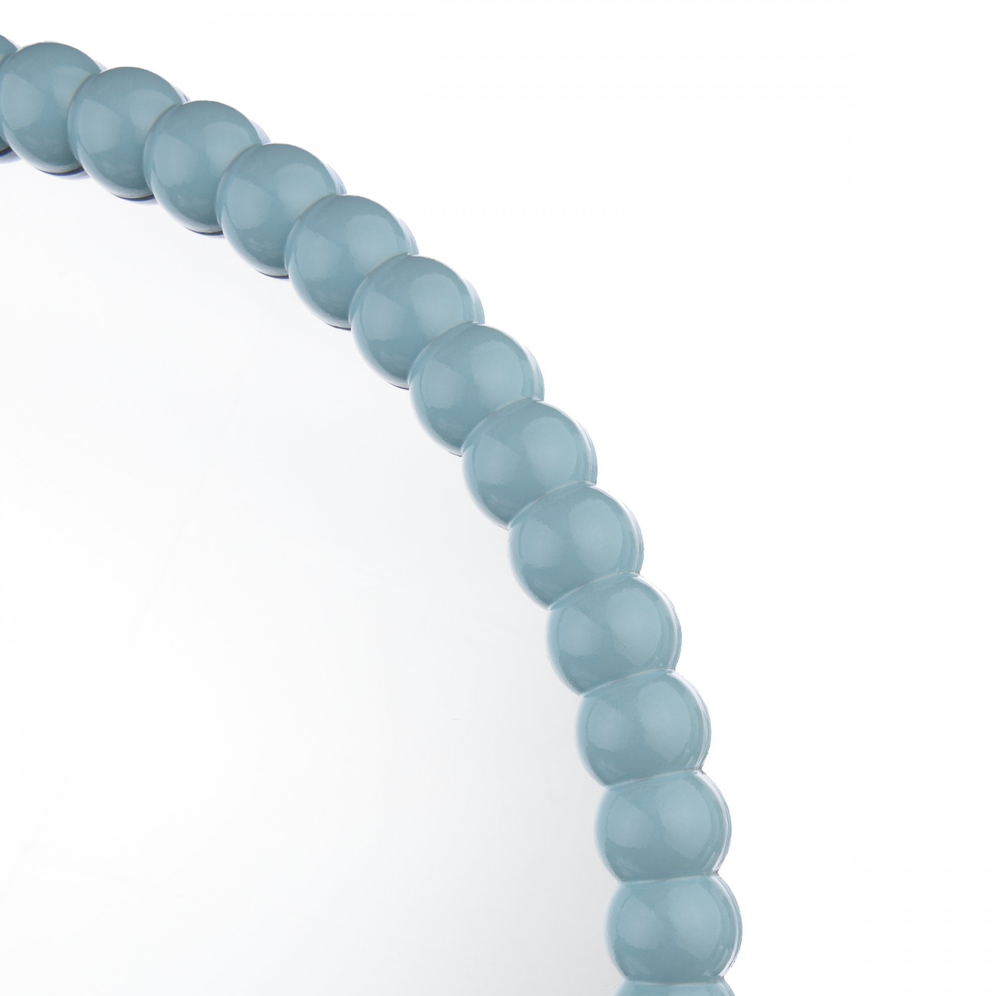Close-up of the light blue beaded frame of a round mirror.