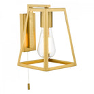 A modern gold wall light with a geometric frame and exposed bulb with a pull cord switch.