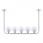 Five clear globe lights on a chrome bar, with two fluted globes, suspended from two ceiling mounts.