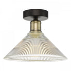A close-up of a fluted glass and antique brass semi-flush ceiling light.