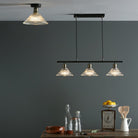 A kitchen scene with a fluted glass and antique brass light fixture installed.