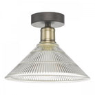 A close-up of a fluted glass and antique brass semi-flush ceiling light.