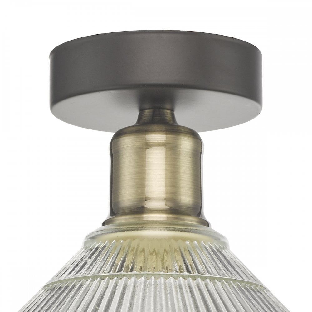 A close-up of the antique brass and dark bronze base of the light fixture.