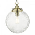 A clear, ribbed glass globe pendant light with brass top, hanging on a white background.