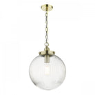 A clear, ribbed glass globe pendant light with brass accents and chain, hanging on a white background.