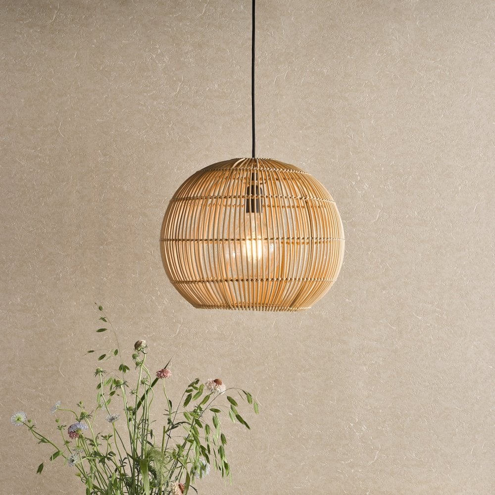 A round, light brown wicker pendant light hangs in a room with a light-colored wall.