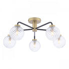 A modern gold and black ceiling light with five clear, textured glass globes.