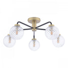 A modern gold and black ceiling light with five clear, textured glass globes.