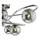 A close-up view of three smoked glass orbs with illuminated bulbs on a chrome light fixture.