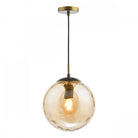 A hanging glass pendant light with a textured amber globe and a brass fixture.