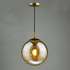 A hanging pendant light featuring an amber textured glass globe and a brass fitting.