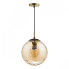 A hanging glass pendant light with a textured amber globe and a brass fixture.