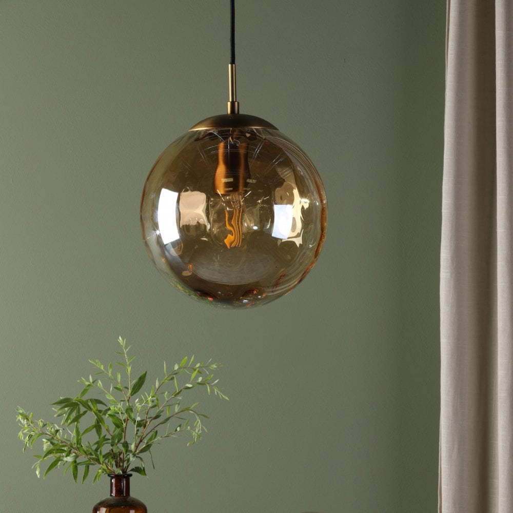 A close-up of a hanging amber glass pendant light providing warm illumination.