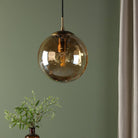 A close-up of a hanging amber glass pendant light providing warm illumination.