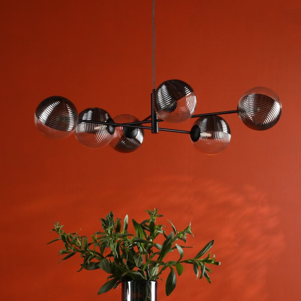 A modern black chandelier with six glass globe shades, half clear and half ribbed silver.