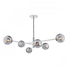 A modern chrome chandelier with six smoked glass globes, casting a warm glow.