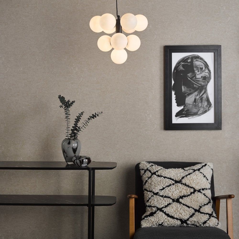 Modern chandelier with ten illuminated white globes in a living room setting.
