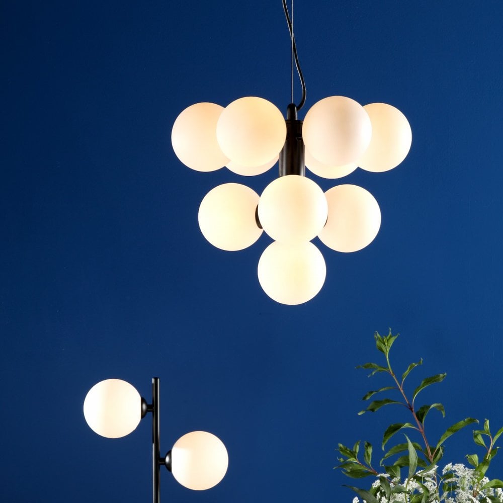 Illuminated modern black chandelier with ten white globes against a blue background.