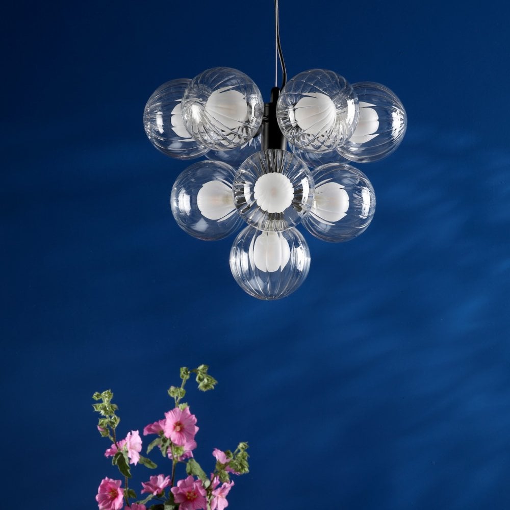 Modern chandelier with seven unlit clear glass globes, black mount, and pink flowers.