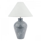 A white tapered lampshade on a grey base with white flowers on a white background.