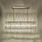 An illuminated rectangular chandelier casting light patterns on a warm-toned wall.